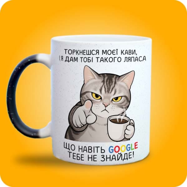 Біла чашка з сердитим котом, кавою та смішним написом "Торкнешся моєї кави", вигляд з лівого боку