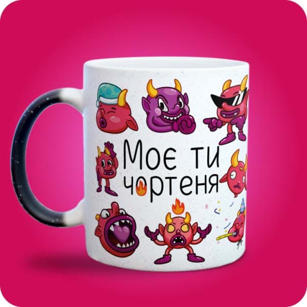 Біла чашка з кумедними кольоровими чортенятами та написом "Моє ти чортеня", вигляд з лівого боку