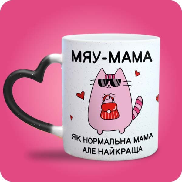 Біла чашка з рожевим котиком в окулярах та написом "Мяу-мама - як нормальна мама, але найкраща", вигляд чашки хамелеон з ручкою сердечко