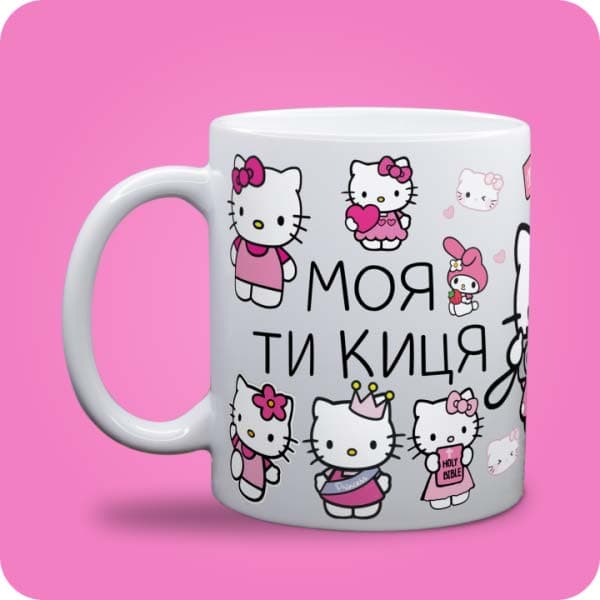 Біла чашка з персонажами Hello Kitty, рожевими деталями та написом "Моя ти киця", вигляд чашки біла з блискітками і без блискіток