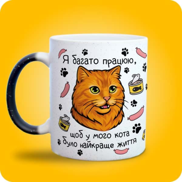 Біла чашка з рудим котом і написом "Я багато працюю, щоб у мого кота було найкраще життя", вигляд з лівого боку