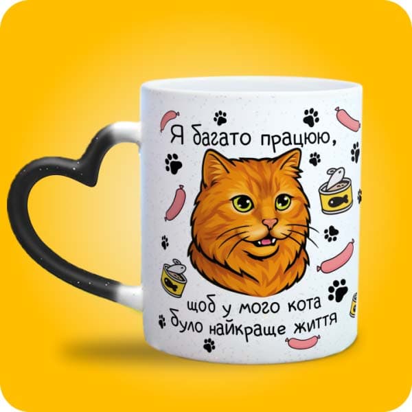 Біла чашка з рудим котом і написом "Я багато працюю, щоб у мого кота було найкраще життя", вигляд чашки хамелеон з ручкою сердечко