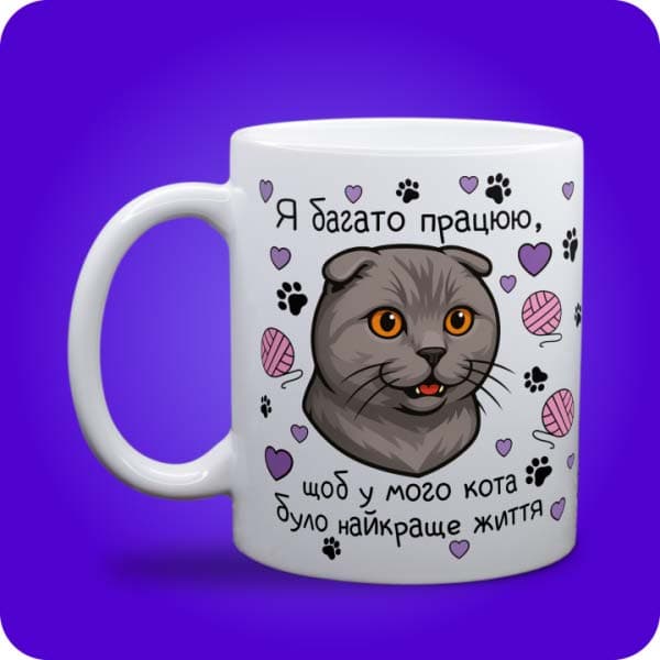 Біла чашка з шотландською висловухою кішкою, сердечками, клубками та написом про найкраще котяче життя, вигляд чашки біла з блискітками і без блискіток