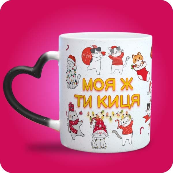 Біла чашка з новорічними котиками у святкових образах та написом "Моя ж ти киця", вигляд чашки хамелеон з ручкою сердечко