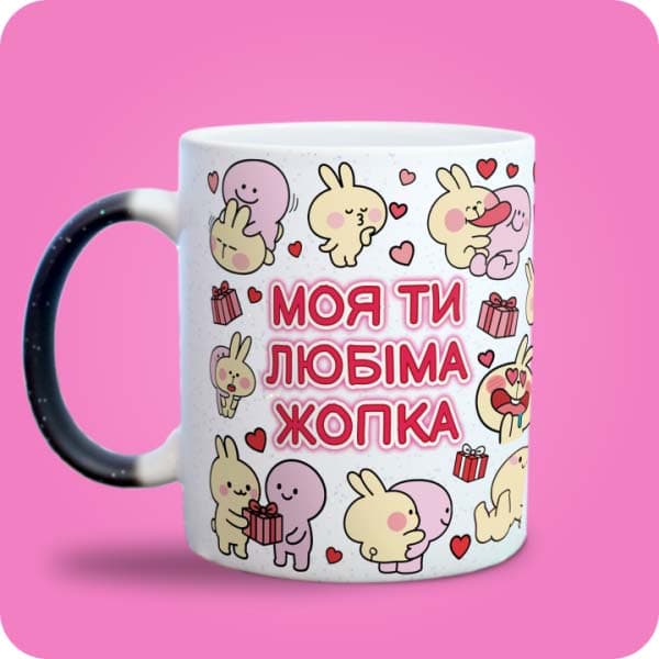 Біла чашка з кольоровими закоханими зайчиками, сердечками та написом "Моя ти любіма жопка", вигляд з лівого боку
