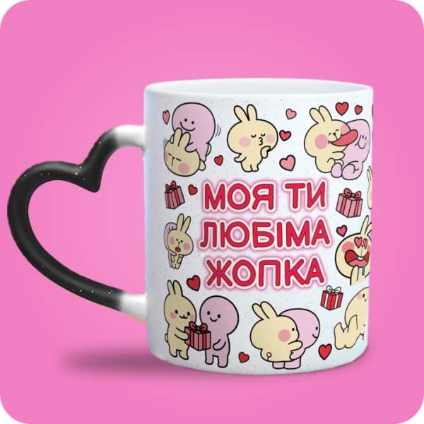Біла чашка з кольоровими закоханими зайчиками, сердечками та написом "Моя ти любіма жопка", вигляд чашки хамелеон з ручкою сердечко