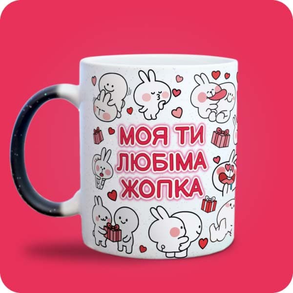 Біла чашка з закоханими білими зайчиками, сердечками та написом "Моя ти любіма жопка", вигляд з лівого боку