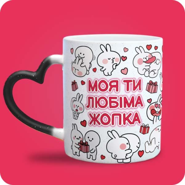 Біла чашка з закоханими білими зайчиками, сердечками та написом "Моя ти любіма жопка", вигляд чашки хамелеон з ручкою сердечко