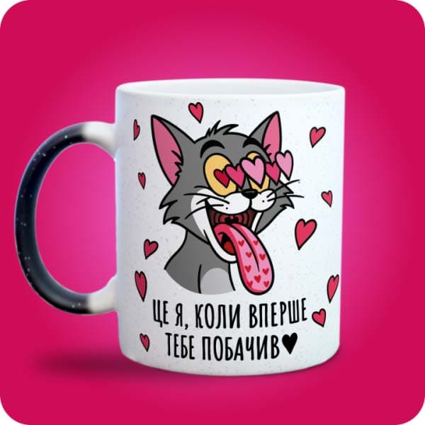 Біла чашка з закоханим сірим котом, очима-сердечками та написом "Це я, коли вперше тебе побачив", вигляд з лівого боку