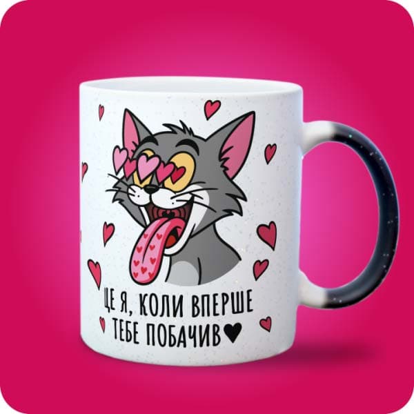 Біла чашка з закоханим сірим котом, очима-сердечками та написом "Це я, коли вперше тебе побачив", вигляд з правого боку