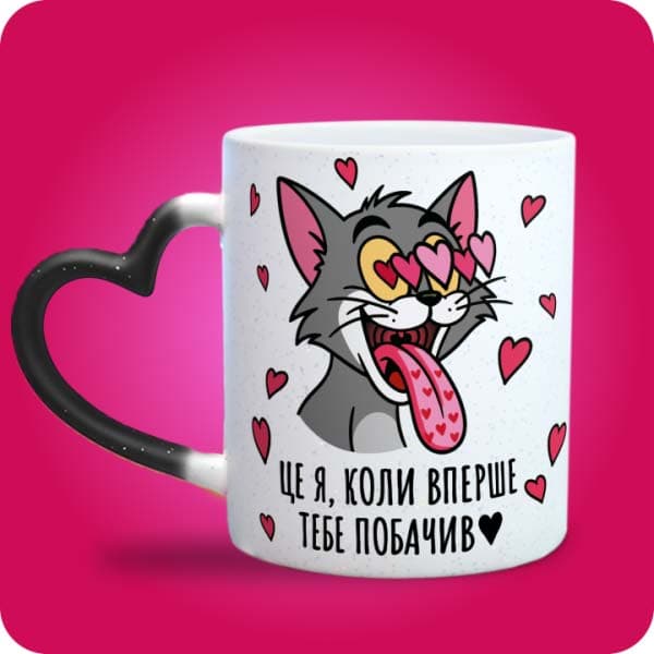 Біла чашка з закоханим сірим котом, очима-сердечками та написом "Це я, коли вперше тебе побачив", вигляд чашки хамелеон з ручкою сердечко