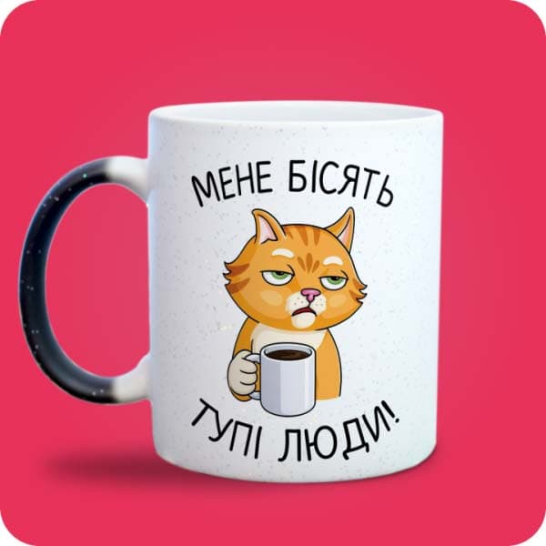 Біла чашка з котом, кавою та написом "Мене бісять тупі люди!", вигляд з лівого боку