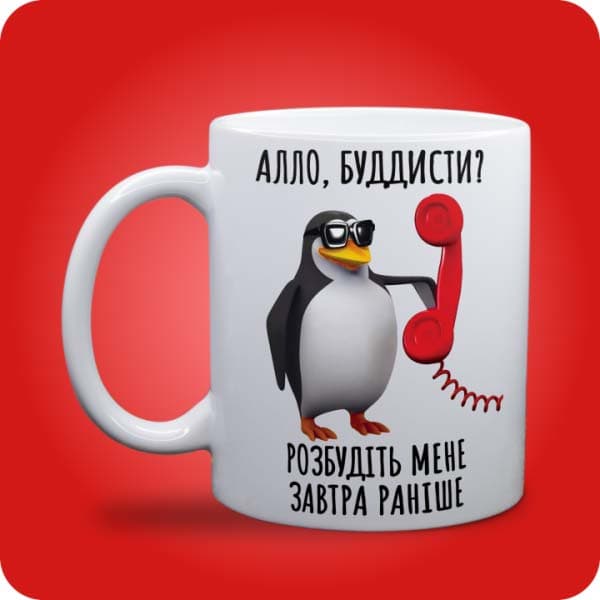 Біла чашка з пінгвіном, телефоном і написом "Алло, буддисти? Розбудіть мене завтра раніше", вигляд чашки біла з блискітками і без блискіток