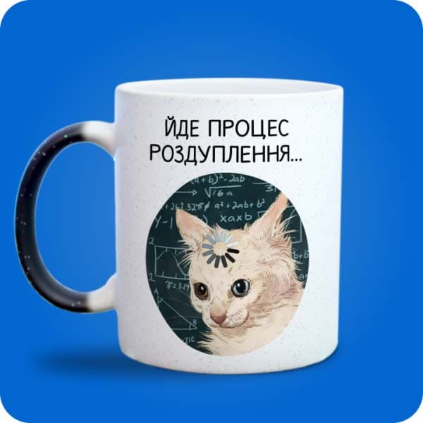 Біла чашка з котом і написом "Йде процес роздуплення", вигляд з лівого боку