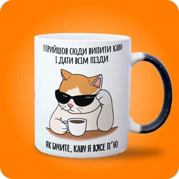 Біла чашка з котом у чорних окулярах, кавою та смішним написом, вигляд з правого боку