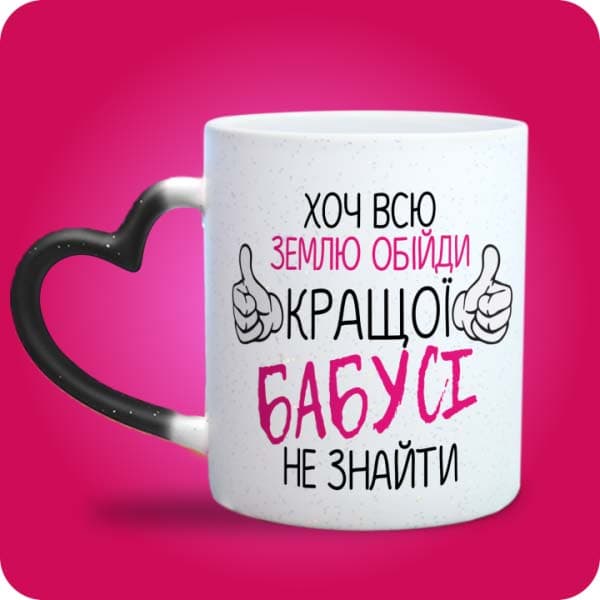 Біла чашка з написом "Хоч всю землю обійди, кращої бабусі не знайти", вигляд чашки хамелеон з ручкою сердечко
