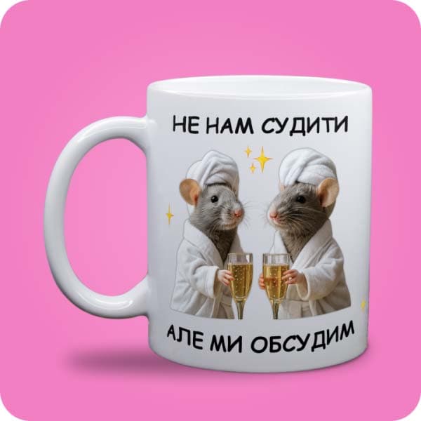 Біла чашка з двома кумедними крисками та написом "Не нам судити, але ми обсудим", вигляд чашки біла з блискітками і без блискіток
