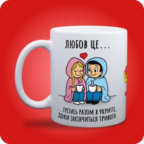 Біла чашка в стилі Love is із закоханою парою під ковдрою та написом "Грітись разом в укритті, доки закінчиться тривога", вигляд чашки біла з блискітками і без блискіток