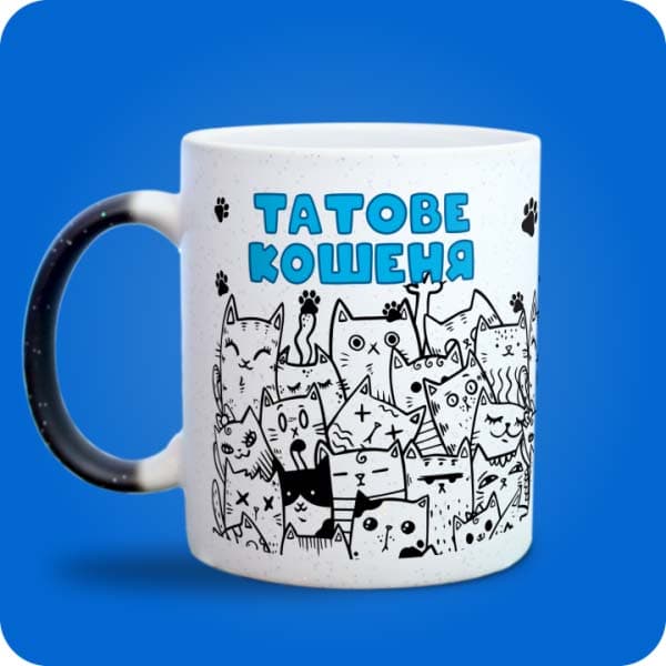 Біла чашка з принтом багатьох кумедних котиків і написом "Татове кошеня", вигляд з лівого боку