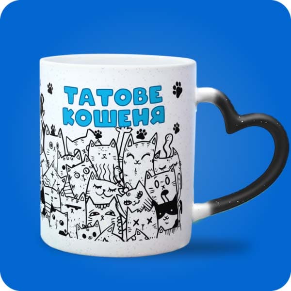 Біла чашка з принтом багатьох кумедних котиків і написом "Татове кошеня", вигляд чашки хамелеон з ручкою сердечко