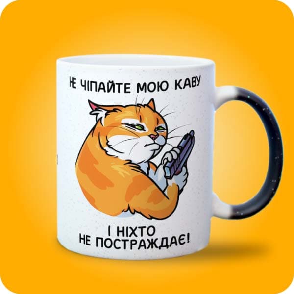 Біла чашка з сердитим рудим котом і написом "Не чіпайте мою каву і ніхто не постраждає", вигляд з правого боку