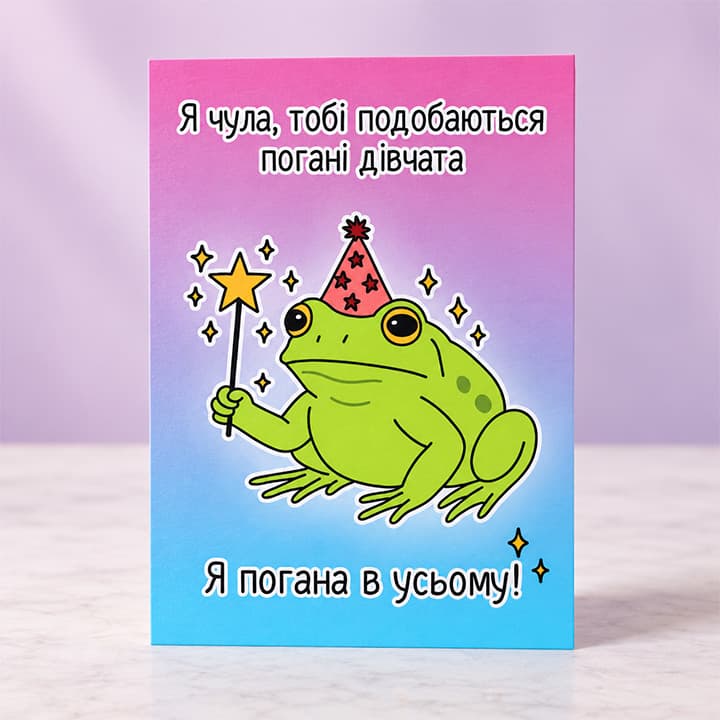 Рожева смішна листівка з жабкою у святковому ковпаку та написом "Я чула, тобі подобаються погані дівчата. Я погана в усьому"